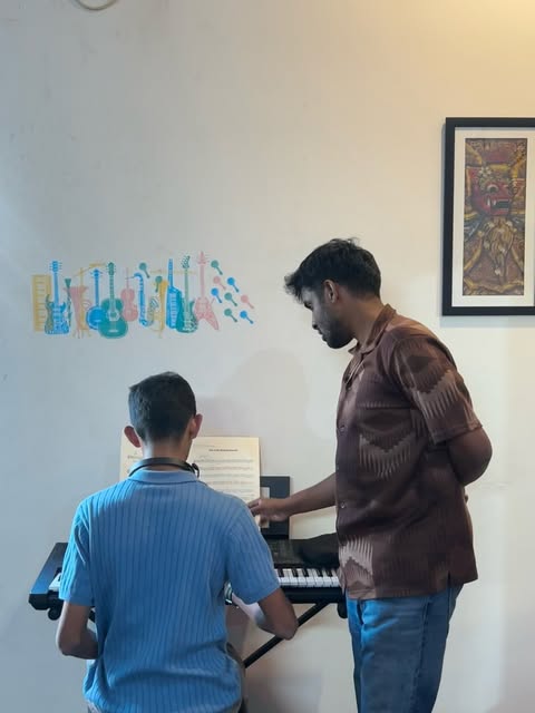 A keyboard student learning with a teacher at SARA Music School